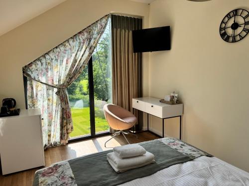 a bedroom with a bed and a desk and a window at Szum Rzeki - Noclegi nad Brdą - Bory Tucholskie in Nadolna Karczma