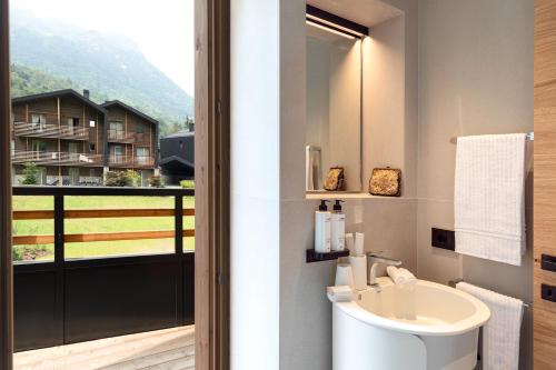 a bathroom with a toilet and a sink and a window at LVG Hotel Collection - Cascata d'Otro Mountain Lodge in Alagna Valsesia