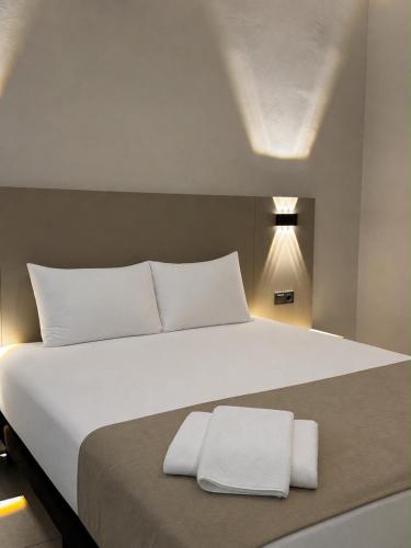 a large white bed with two white towels on it at Er Suite in Alanya