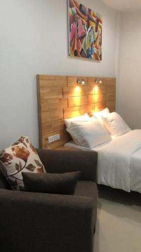 a hotel room with a bed and a couch and a bed at Afrilodge Liberia in Monrovia