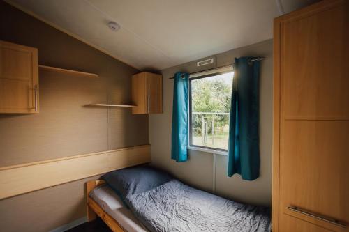 a small bedroom with a bed and a window at Tiny House Kleinrettbach 
