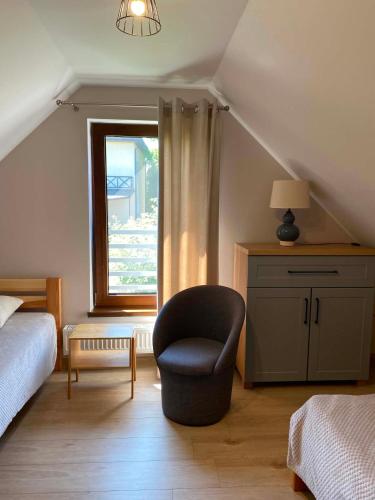 a bedroom with a chair and a window at Domowe Zacisze in Augustów