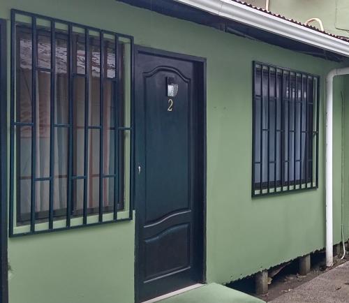 a black door on the side of a building at Apartamentos Caimán Tortuguero in Tortuguero