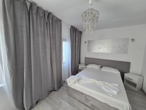a bedroom with a bed and a chandelier at YANNIS GUEST HOUSE in Costinesti