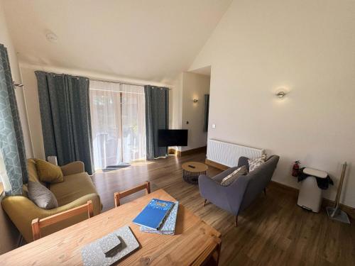 a living room with a couch and a table at Maple Lodge Cottage in Blagdon