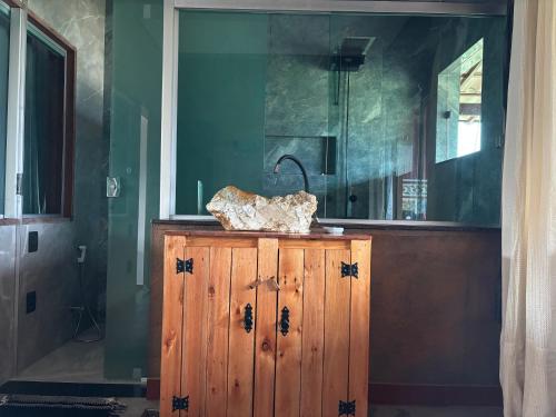 a wooden cabinet in a room with a mirror at Vila Literária Tabuleiro in Conceição do Mato Dentro