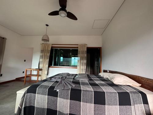 a bedroom with a bed with a black and white checkered blanket at Vila Literária Tabuleiro in Conceição do Mato Dentro
