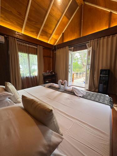 a large white bed in a room with a window at joe Dive resort in Pulau Lembeh
