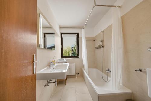 a bathroom with a tub and a sink and a bath tub at Kaprun Apartments in Kaprun