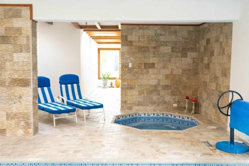 a bathroom with blue chairs and a tub at BUHO Luxury Guayllabamba Home BBQ Jacuzzi Pool in Quito