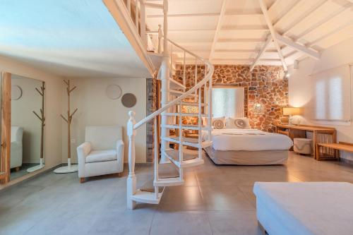 a bedroom with a bed and a staircase in a room at Oikies Small Elegant Houses in Mytilene