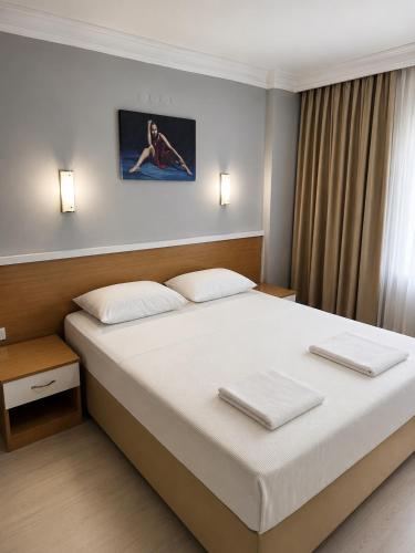 a bedroom with a large white bed with two pillows at Butik İsabel Otel in Kemer