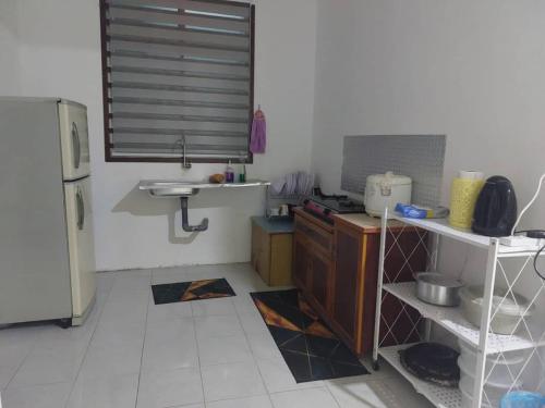 a small kitchen with a sink and a refrigerator at KASIH JERAI HOMESTAY, Gurun, Guar Chempedak in Guar Chempedak