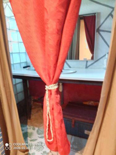 a red curtain in a bathroom with a mirror at Chez Hinano SIKI in Bora Bora