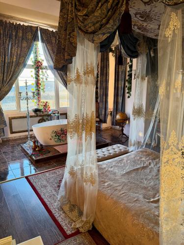 a bedroom with a canopy bed and a bath tub at Chateau Vincze in Sátoraljaújhely