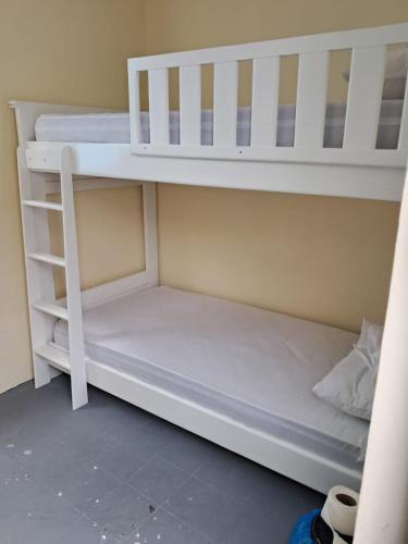 a white bunk bed with a ladder next to at casa celia in Asilah