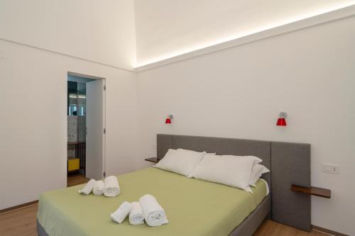 a bedroom with a bed with white slippers on it at Design Apartment in Monopoli