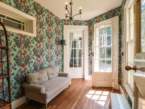 a living room with a couch and floral wallpaper at Bardon Hill Manor in Coalville