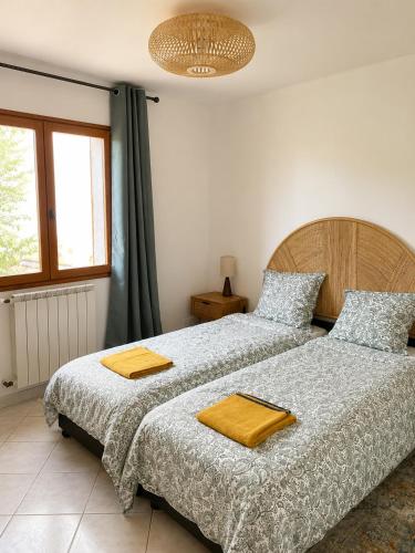 a bedroom with two beds with towels on them at La Bastide Rempelin in Aix-en-Provence
