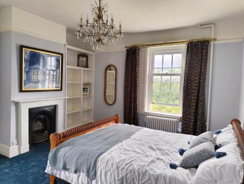 a bedroom with a bed and a fireplace and a chandelier at Bardon Hill Manor in Coalville