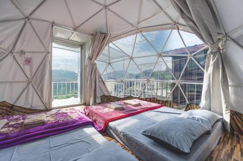 two beds in a room with a large window at Mon P Monjam in Mon Jam