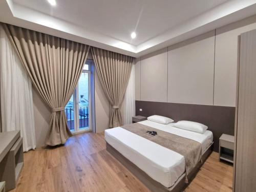 a bedroom with a bed and a large window at Leonida Residence in Taranto