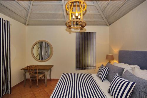 Un dormitorio con una cama, una mesa y una lámpara de araña. en Fisherman's Cottage, en Kalamakia