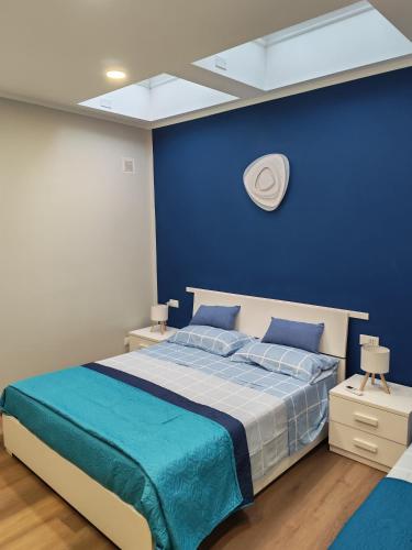 a blue bedroom with a bed with a blue wall at B&B Il Dolce Castello di Balestrino in Balestrino