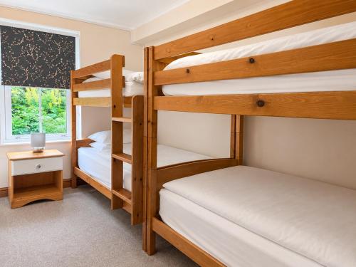 a bedroom with two bunk beds and a window at Howgills Apartments in Sedbergh