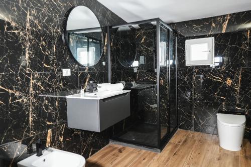 a black marble bathroom with a sink and a mirror at Leonida Residence in Taranto