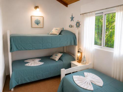 a bedroom with two bunk beds and a window at Tierra Mora Casas de alquiler in Villa Gesell
