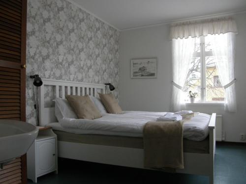 sypialnia z łóżkiem z umywalką i oknem w obiekcie Monicas Rumsuthyrning w mieście Borgholm