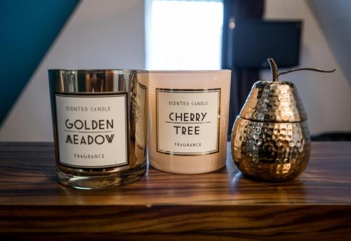 two candles and a vase on a wooden table at Linden Hotel in Amsterdam