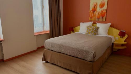 a bedroom with a large bed in a room at Logis-Hôtel des Oliviers in Thionville