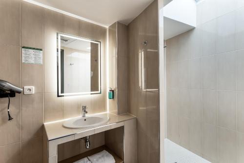 a bathroom with a sink and a mirror at Hotel Molière in Cannes