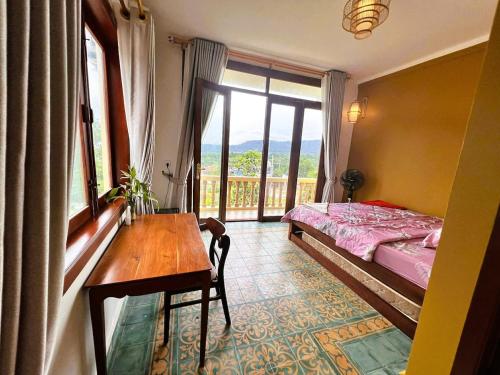 a bedroom with a bed and a table and a window at Family-friendly accomodation with sea view in Kaôh Kon