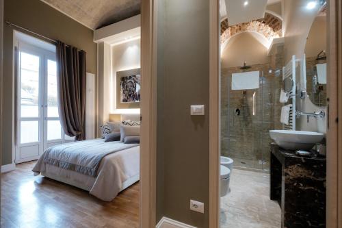 Apart Hotel Torino في تورينو: غرفة نوم بسرير وحمام مع حوض