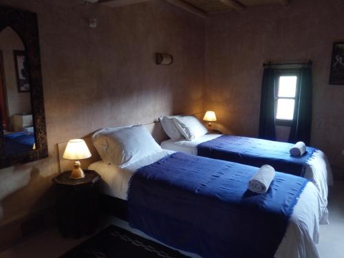 a bedroom with two beds and a mirror and two lamps at La Kasbah d'Ouzoud in Ouzoud