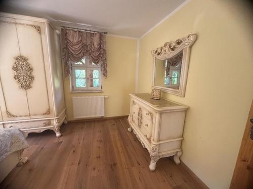 a bedroom with a dresser and a mirror on the wall at Zum Böhmen Ferienwohnung Fridericke in Bad Langensalza