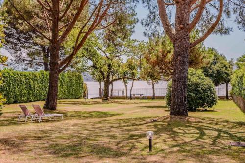 two chairs sitting in a park with trees at Large lakeside villa in Lesa