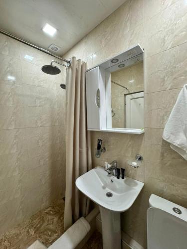 ein Badezimmer mit Waschbecken und Dusche mit Spiegel in der Unterkunft Skypiea Hotel in Yerevan