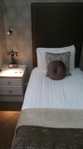 a bedroom with a bed with a pillow on it at Glendower Hotel BW Signature Collection in Lytham St Annes