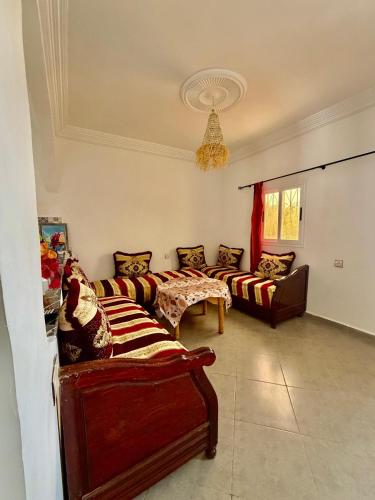 a living room with couches and a chandelier at Dar Rime in Ghazoua
