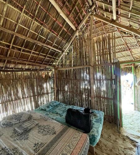 a room with a bed in a straw hut at Arriyaladub traditional cabins San blas in Masargantupo