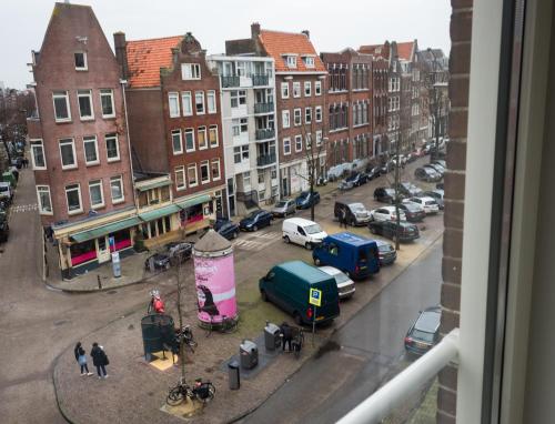a view from a window of a city street with cars at Linden Hotel in Amsterdam