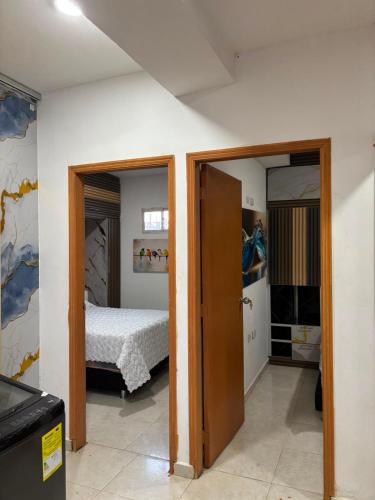 a bedroom with a bed and an open door at Edificio Villa Linda Urb El Parque in Barranquilla