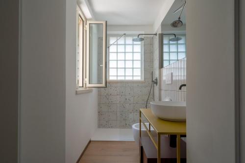 a bathroom with a white sink and a window at Design Apartment in Monopoli