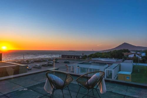 a couple of chairs sitting on a balcony with the sunset at Moledo Front Beach by Portugal Active in Viana do Castelo