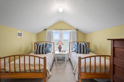 two beds in a room with a window at Harbor Island 71 Harbor Drive in Nautical Watch Villas