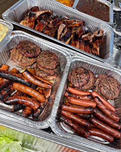 a tray of hot dogs and hamburgers and other foods at BelizeprivateChef in Dangriga
